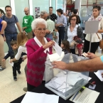 Una señora vota en el centro Miquel Martí i Pol 