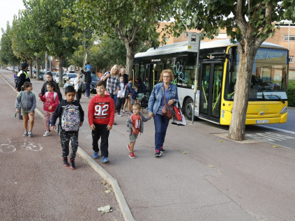Infants arribant en bus a l'escola